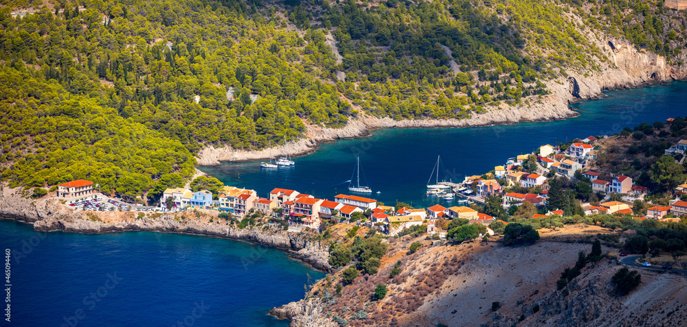 Obraz premium Assos village in Kefalonia, Greece. Turquoise colored bay in Mediterranean sea with beautiful colorful houses in Assos village in Kefalonia, Greece, Ionian island, Cephalonia, Assos village.