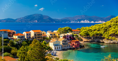 Fototapeta Naklejka Na Ścianę i Meble -  Turquoise colored bay in Mediterranean sea with beautiful colorful houses in Assos village in Kefalonia, Greece. Town of Assos with colorful houses on the mediterranean sea, Greece.
