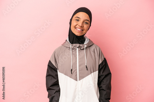 Young Arab woman with sport burqa isolated on pink background happy, smiling and cheerful.
