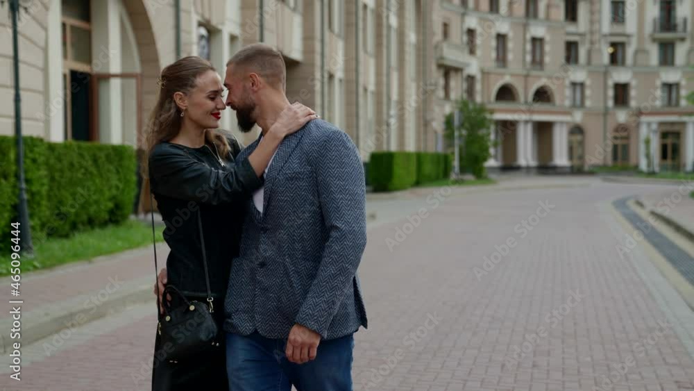 happy loving couple is walking in city, hugging and holding hands happy loving couple is walking in city, hugging and holding hands