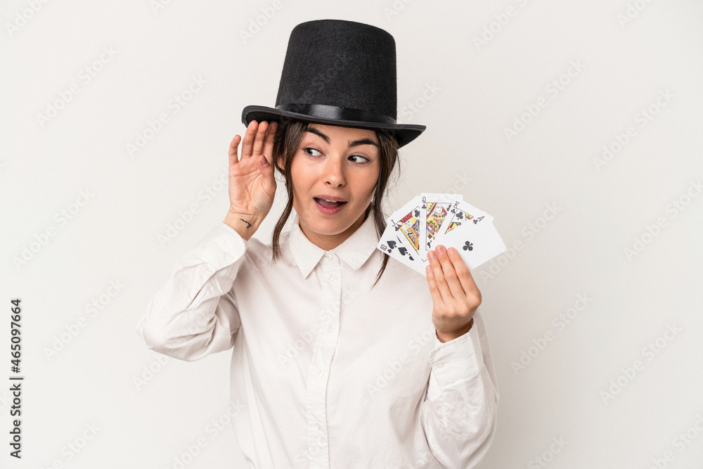 Young magician woman holding a wand isolated on white background trying to listening a gossip. Young magician woman holding a wand isolated on white background trying to listening a gossip.