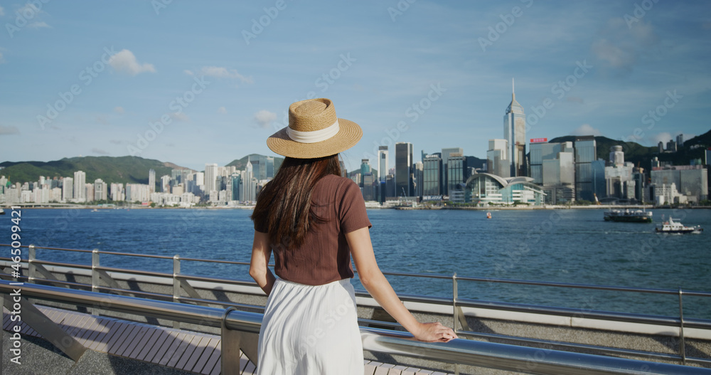 Woman look at the Victoria harbor in Hong Kong