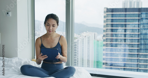 Free Download Woman sit on the bed and use of tablet computer - GFXLoad