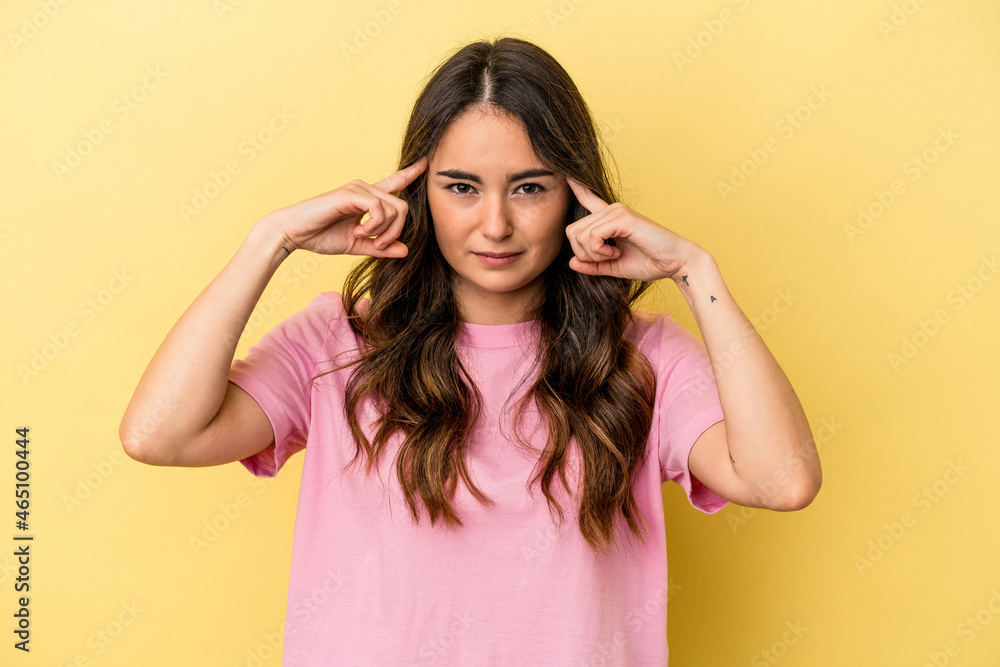 Young caucasian woman isolated on yellow background focused on a task, keeping forefingers pointing head. Young caucasian woman isolated on yellow background focused on a task, keeping forefingers pointing head.