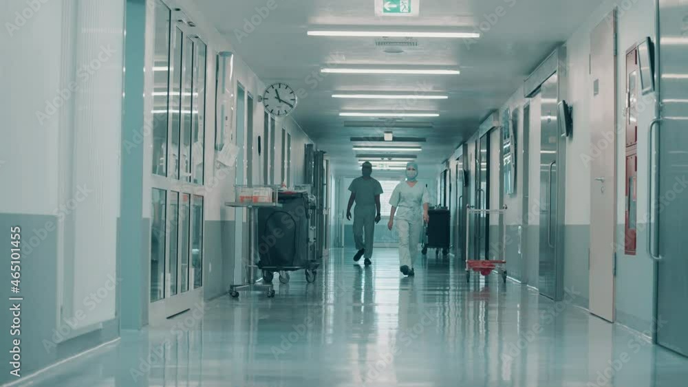 Hallway with surgeons in medical uniform walking along it