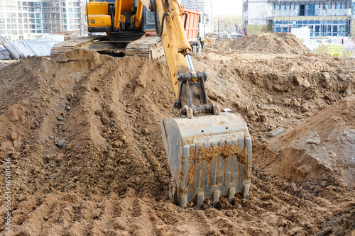 Photo of an excavator that digs the ground at a construction site