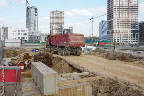 Photo of a truck at the construction site of multi-storey buildings in the city