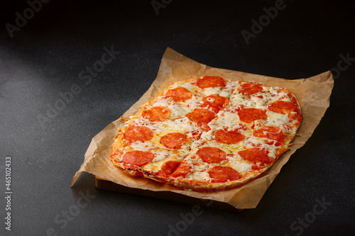 pepperoni roman pizza closeup. pepperoni pizza on dark concrete table