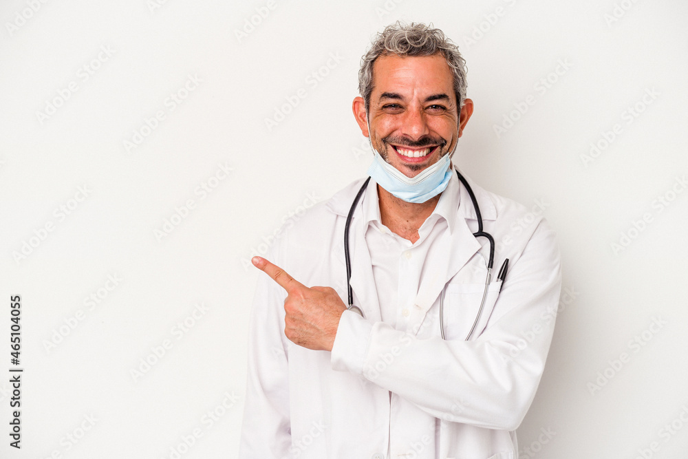 Middle age doctor man wearing a mask for virus isolated on white background smiling and pointing aside, showing something at blank space. Middle age doctor man wearing a mask for virus isolated on white background smiling and pointing aside, showing something at blank space.