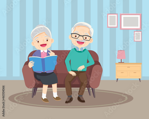 happy elderly reading book together on sofa