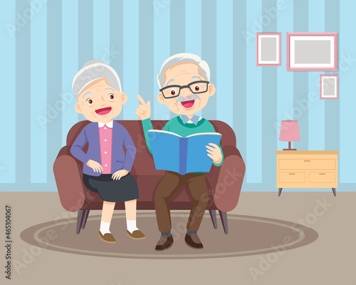 elderly reading book together on sofa