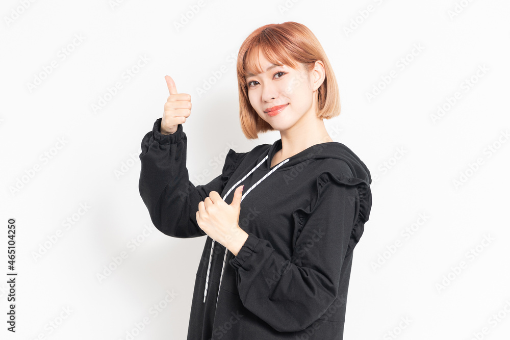 いいねのジェスチャーをする若い女性 いいねのジェスチャーをする若い女性