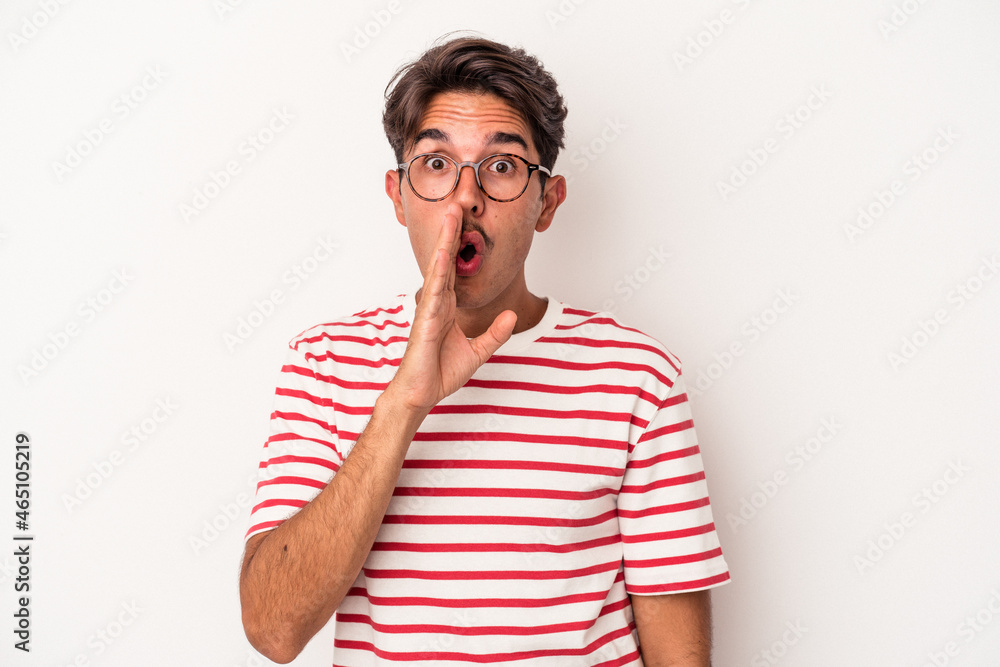 Young mixed race man isolated on white background is saying a secret hot braking news and looking aside Young mixed race man isolated on white background is saying a secret hot braking news and looking aside