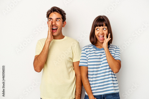 Young mixed race couple isolated on white background shouting excited to front.