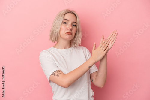 Young caucasian woman isolated on pink background feeling energetic and comfortable, rubbing hands confident.