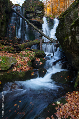 Waterfall  river  rocks covered with green moss  forest. Carpathians dense forest in the center of the forest with a waterfall. Quiet and pleasant environment for tourism. 