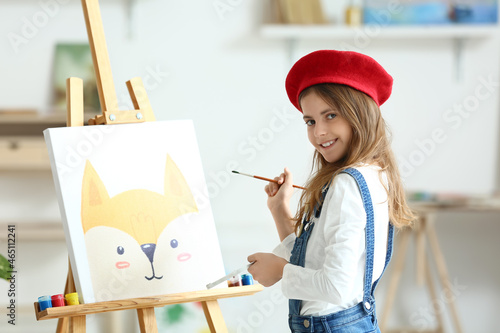 Cute little girl painting a...
