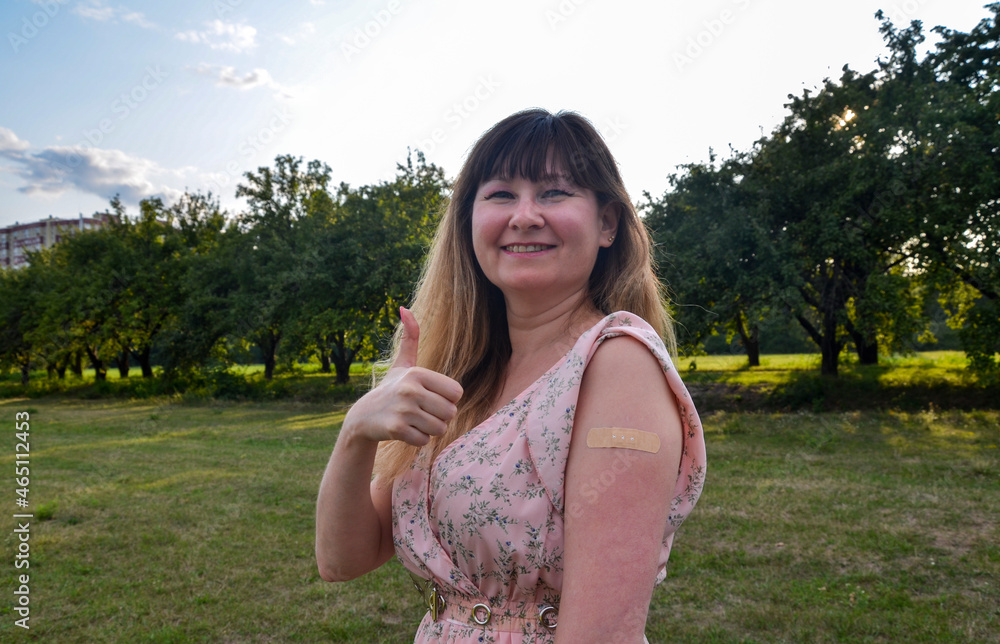 Young woman with plaster in her hand smiling and showing thumb up gesture after getting coronavirus vaccine. Concept of people vaccination
Young woman with plaster in her hand smiling and showing thumb up gesture after getting coronavirus vaccine. Concept of people vaccination