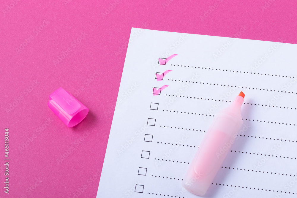 Check list with pink marked points and marker on pink background Stock
