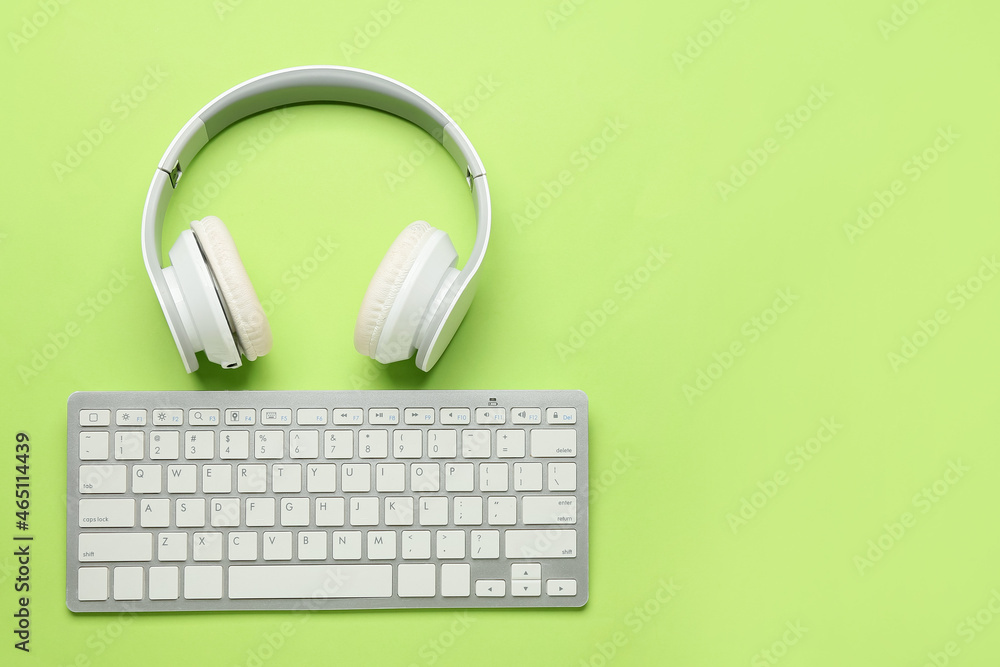 Headphones and keyboard on green background Headphones and keyboard on green background