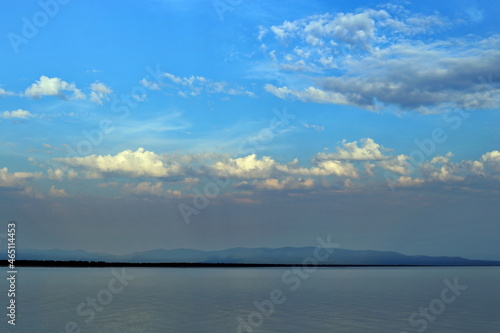 Beautiful sunset sky with clouds over Lake Baikal, Russia. View from the Peninsula Holy Nose. Summer. Beautiful evening sky with multi-colored bright clouds.