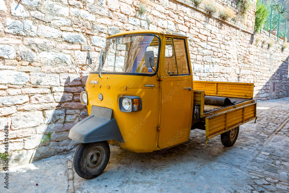 A old yellow Piaggio P 601 Ape Car is a three-wheeled light commercial vehicle produced since 1948 by Piaggio