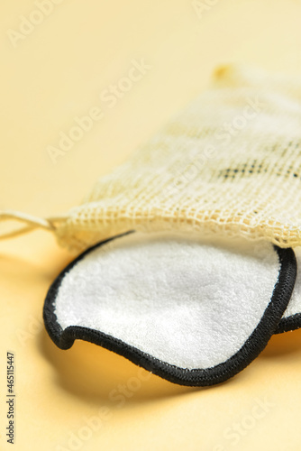 Bag with reusable cotton pads on yellow background