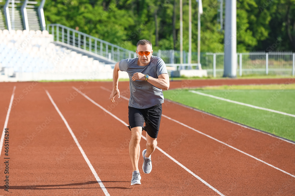 Sporty mature man running at stadium