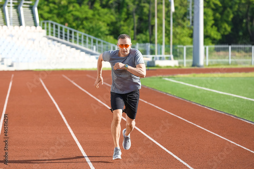 Sporty mature man running at stadium