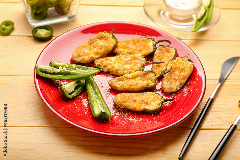 Plate with tasty jalapeno poppers on wooden background, closeup Plate with tasty jalapeno poppers on wooden background, closeup