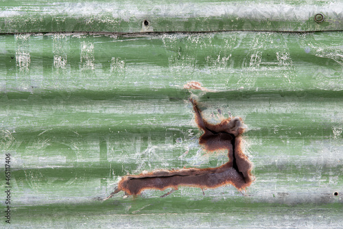 Old and aged corrugated metal painted green.
