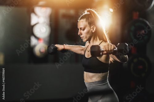 Muscular Woman Doing Training With Dumbbell At The Gym