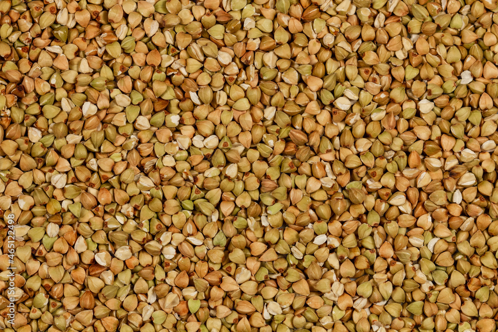 Natural Green Raw Buckwheat Groats. Raw not steamed buckwheat grains. Organic buckwheat grains ready for cooking porridge. Ecologically clean healthy food. Gluten Free. GMO Free. Top view. Close-up Natural Green Raw Buckwheat Groats. Raw not steamed buckwheat grains. Organic buckwheat grains ready for cooking porridge. Ecologically clean healthy food. Gluten Free. GMO Free. Top view. Close-up