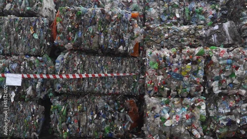 Bundle of pressed plastic bottles prepared for a garbage recycling on waste recycling plant. Camera moves to the side. Pollution problem. Stabilized video