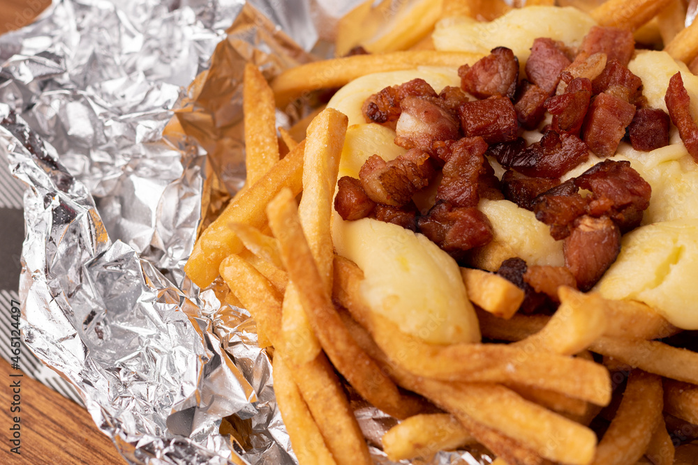 Portion of fries with cream cheese and diced bacon Portion of fries with cream cheese and diced bacon