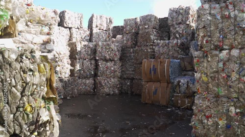 Bundle of pressed plastic bottles prepared for a garbage recycling on waste recycling plant. Camera moves forward. Pollution problem. Stabilized video