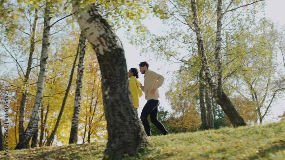 Young man and woman running on the stairs at the park in sunny autumn morning. Couple of young people having morning exercises. Work out together with a partner. High quality 4k footage Young man and woman running on the stairs at the park in sunny autumn morning. Couple of young people having morning exercises. Work out together with a partner. High quality 4k footage