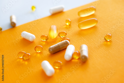 Yellow capsules of nutraceuticals in spoon. Pills and meds. photo