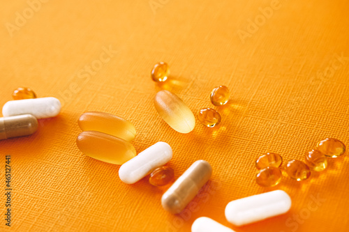 Yellow capsules of nutraceuticals in spoon. Pills and meds.