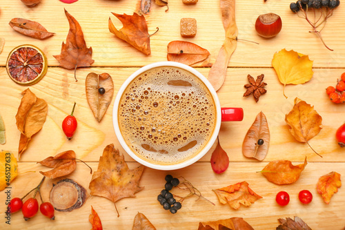 Beautiful autumn composition with cup of coffee and leaves on wooden background