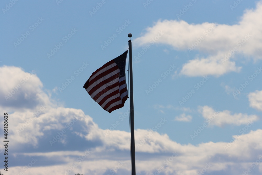 american flag waving against blue cloudy sky american flag waving against blue cloudy sky