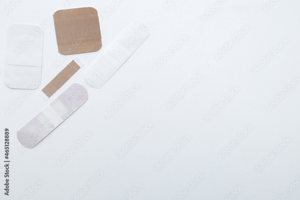 Bactericidal patches of various shapes and sizes lie on a white background with a place for text. High quality photo Bactericidal patches of various shapes and sizes lie on a white background with a place for text. High quality photo