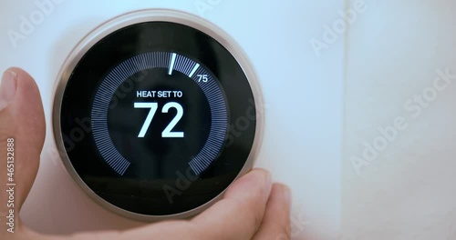 A person lowering the temperature on a Smart Thermostat on fahrenheit scale