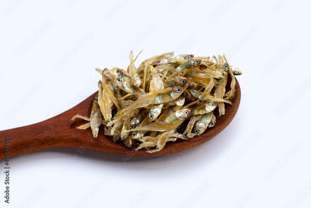 Dried anchovy in wooden spoon on white background.