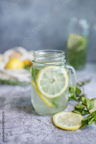 fresh lemonade on grey background  biologic lemons and mint. a glass of citrus lemonade
