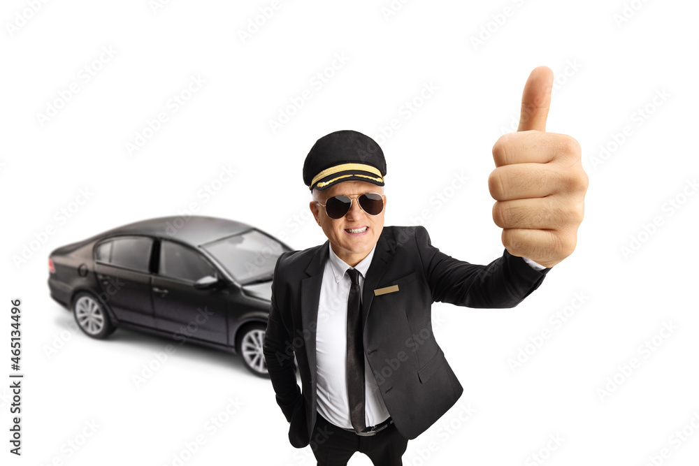 Cheerful chauffeur in a uniform showing thumbs up in front of a black car Cheerful chauffeur in a uniform showing thumbs up in front of a black car