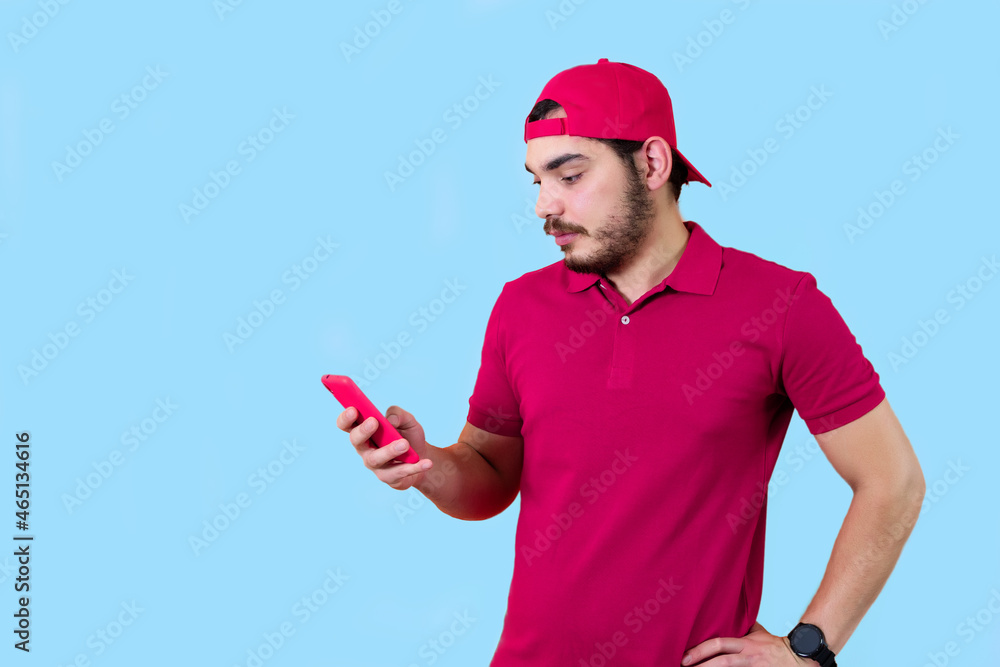 Photo portrait of man keeping mobile phone reading news isolated on light blue color background. Photo portrait of man keeping mobile phone reading news isolated on light blue color background.