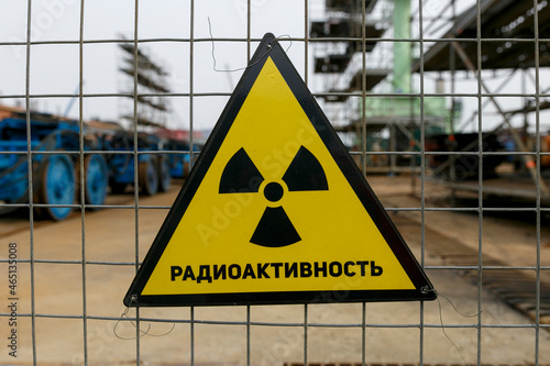 Radioactivity triangular sign on the fence. The radioactivity warning sign hangs in front of the danger zone.
