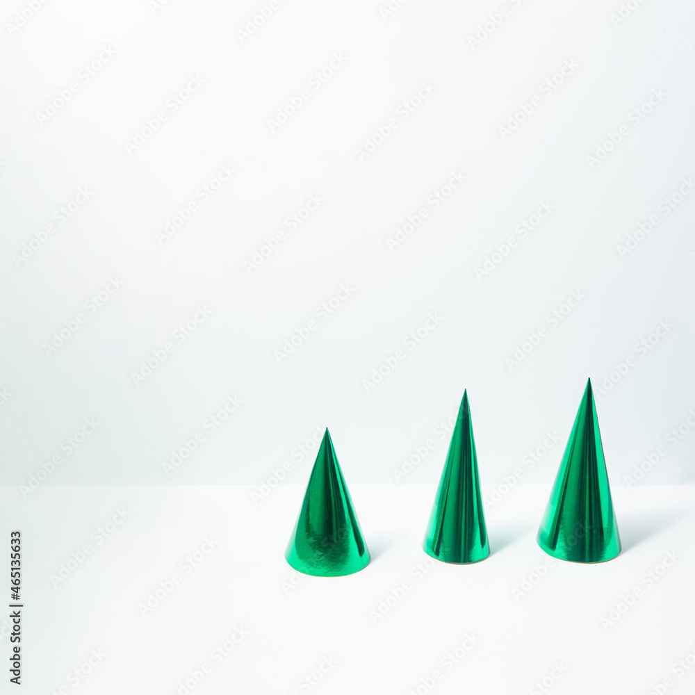Minimalistic Christmas tree concept. Shiny green forest on snowy white background. New Year composition. Winter holiday idea. Minimalistic Christmas tree concept. Shiny green forest on snowy white background. New Year composition. Winter holiday idea.