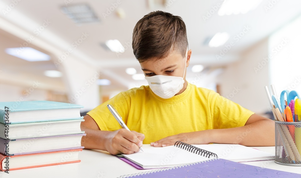 Naklejka premium School students wearing masks and studying in the classroom.